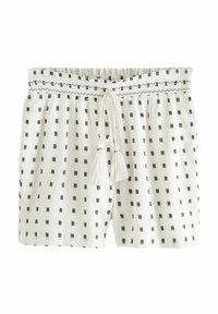 Vita shorts med svarta geometriska mönster, dragsko i midjan och tofsdetaljer; tillverkade i lätt, texturerad tyg.
