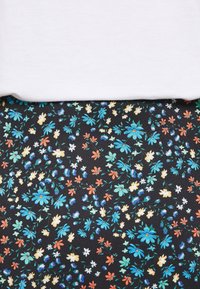 Florales Kleid mit schwarzem Hintergrund, verziert mit blauen, orangefarbenen und weißen Blumen; kombiniert mit einem schlichten weißen Oberteil oben.