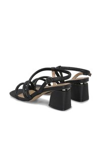 Sandalias negras con tiras, presentando un upper texturizado con acentos de brillo, una puntera cuadrada y un tacón cuadrado para mayor estabilidad.