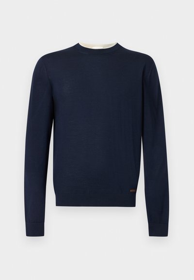 Pull à manches longues bleu marine avec col ras du cou, poignets et ourlet côtelés, orné d'une petite broderie de logo près du bas.