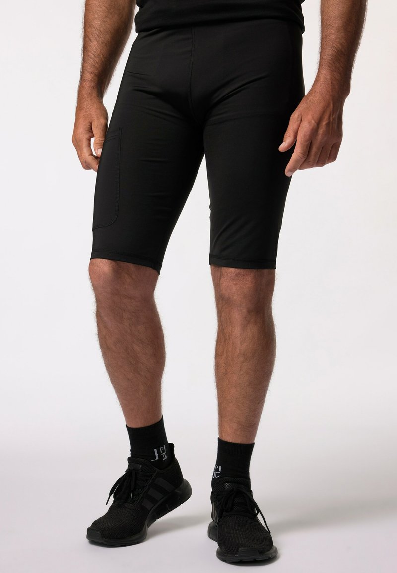 Shorts de sport noirs en tissu lisse et extensible avec une coupe ajustée, dotés d'une poche latérale et d'une longueur au-dessus du genou.
