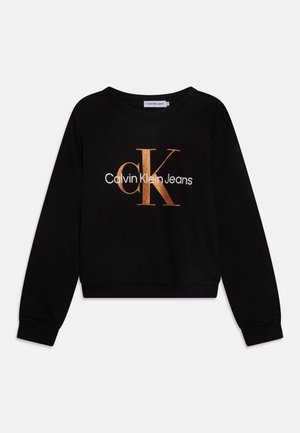 Czarna bluza z długim rękawem z metalicznym różowo-złotym logo „cK” i białym napisem „Calvin Klein Jeans” na przodzie, ze ściągaczami na mankietach i u dołu.