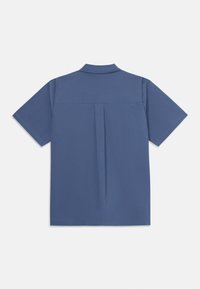 Košeľa s krátkym rukávom z tmavosivej látky, ktorá má stojací golier, prehnutie na zadnej strane a čistý, minimalistický dizajn.