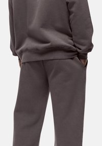 Gray cotton sweatshirt and matching pants, featuring a relaxed fit and ribbed cuffs. Soft texture with minimal design details.