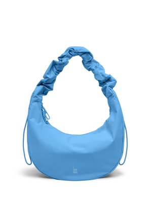 Light blue crescent-shaped handbag with ruched shoulder strap and small brand text "GOT BAG" centered near the bottom.
