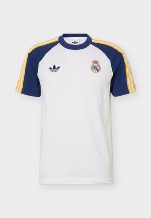White short-sleeve sports shirt with navy blue shoulders, yellow stripes, Adidas logo on left chest, and Real Madrid crest on right chest.