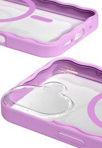 Violets telefona vāciņš ar viļņveida malu dizainu, caurspīdīga sirds izgriezuma forma un zelta teksts "IDEAL OF SWEDEN". Gluda plastmasas tekstūra.