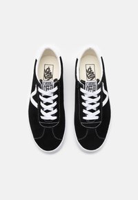 Black suede sneakers with white laces and accents. Design features rounded toe, contrasting stitching, and logo on the tongue.