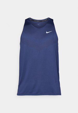 Marineblå ermeløs sportstopp med teksturert mønster, rund hals og hvit Nike-logo på brystet. Laget av lett materiale.