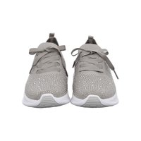 Paar grauer Stricksneaker mit breiten Schnürsenkeln, funkelnden Details und weißen Sohlen, von vorne auf weißem Hintergrund gezeigt.