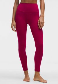 Dopasowane legginsy w jasnym magencie, wykonane z elastycznego materiału. Wysoki pas o gładkiej fakturze, bez widocznych wzorów czy detali metalowych.