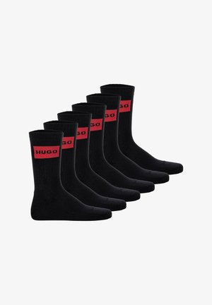 Black cotton socks with ribbed texture, featuring red "HUGO" branding. Set of six, mid-calf length, reinforced heels and toes.