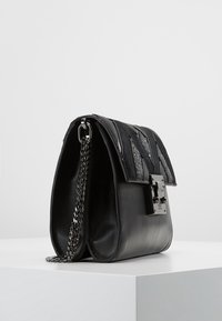 Czarna skórzana torebka z teksturowaną klapką ozdobioną metalicznymi akcentami, łańcuszkowym paskiem i kwadratowym zapięciem. Smukły i dobrze zdefiniowany design.