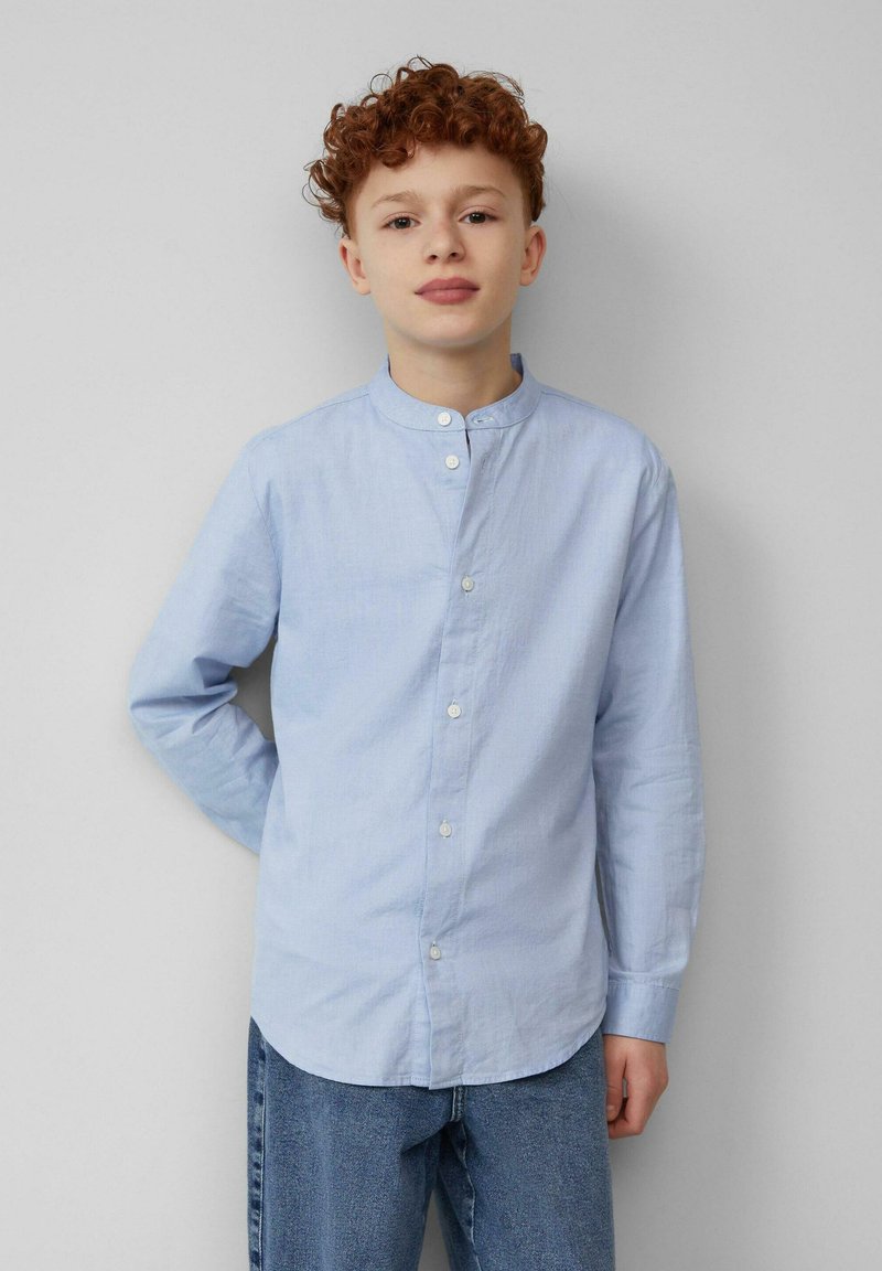 Lichtblauw overhemd met lange mouwen, bandkraag, knopen aan de voorkant en een relaxte pasvorm. Draagt met denim jeans, wat een casual stijl benadrukt.