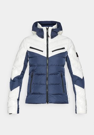 Geacă căptușită cu un scheme de culori albastru închis și alb, design în zigzag, buzunare cu fermoar și glugă cu închidere prin butoane.