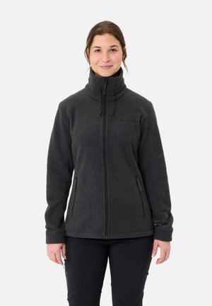 Veste en polaire noire avec col haut, fermeture éclair sur le devant, poches latérales zippées et poignets élastiques. Texture douce avec un design ajusté.