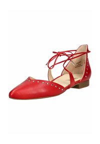 Bailarinas rojas de cuero con punta afilada, que presentan un diseño con recortes, cintas en el tobillo y acentos de tachuelas plateadas a lo largo de los lados. Tacón bajo.