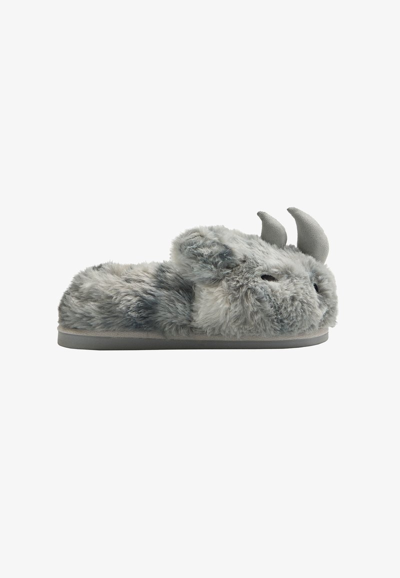 Zapatillas de felpa gris con detalles de cuernos, diseño redondeado, textura suave y suela plana gris. Presentan detalles que parecen un rostro en la parte delantera.