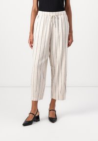Pantaloni in misto lino beige chiaro con strisce verticali blu navy, vita elastica con cordoncino, polsini tapered e tasche laterali.