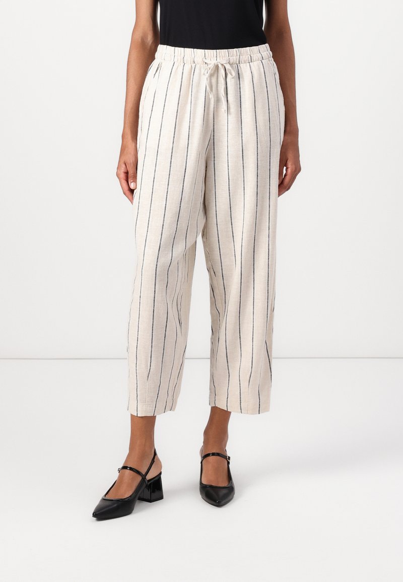 Pantaloni in misto lino beige chiaro con strisce verticali blu navy, vita elastica con cordoncino, polsini tapered e tasche laterali.
