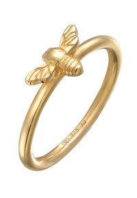 Goldfarbener Metallring mit einem Bienenmotiv, das detaillierte Flügel und einen Körper zeigt. Glatter Ring mit eingestempelten Markierungen auf der Innenseite.