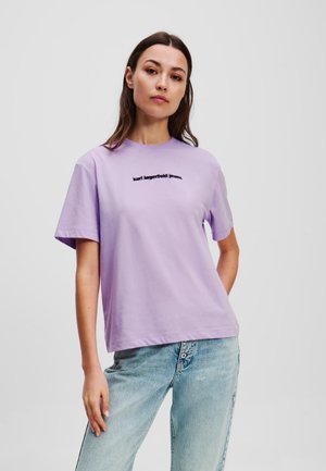 Lavender cotton t-shirt with short sleeves and a crew neck, featuring black text "karl lagerfeld jeans" across the front.