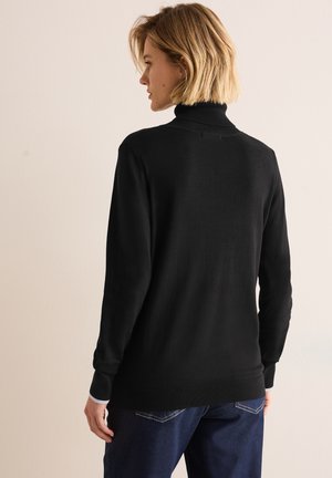 Pull à col roulé noir avec manches longues, poignets et ourlet côtelés. Dispose d'une texture douce. Design simple, adapté pour le superposition.