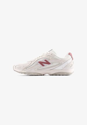 White athletic shoe with red accents. Mesh and synthetic upper, rounded toe, cushioned sole with grip. Features a prominent logo on side.