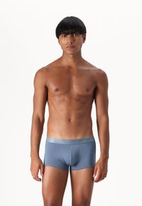 Men's blue cotton boxer briefs with a silver elastic waistband, featuring a snug fit and smooth texture, standing on a plain background.