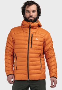 Gefütterte orange Jacke mit Kapuze, horizontal gesteppter Gestaltung, schwarzen Reißverschlussdetails und einem kleinen Logo auf der Brust.