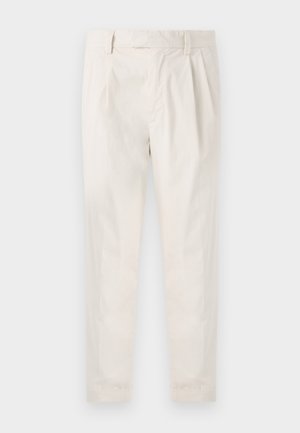 Pantalons blancs plissés avec une coupe ajustée, dotés d'une texture lisse, de passants de ceinture et de jambes fuselées. Pas de poches visibles ni de motifs.