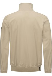 Svetlo béžová bomber bunda, hladká tkanina, vysoký golier, elastické manžety a lem, minimalistický dizajn, žiadne viditeľné vzory ani kovové detaily.