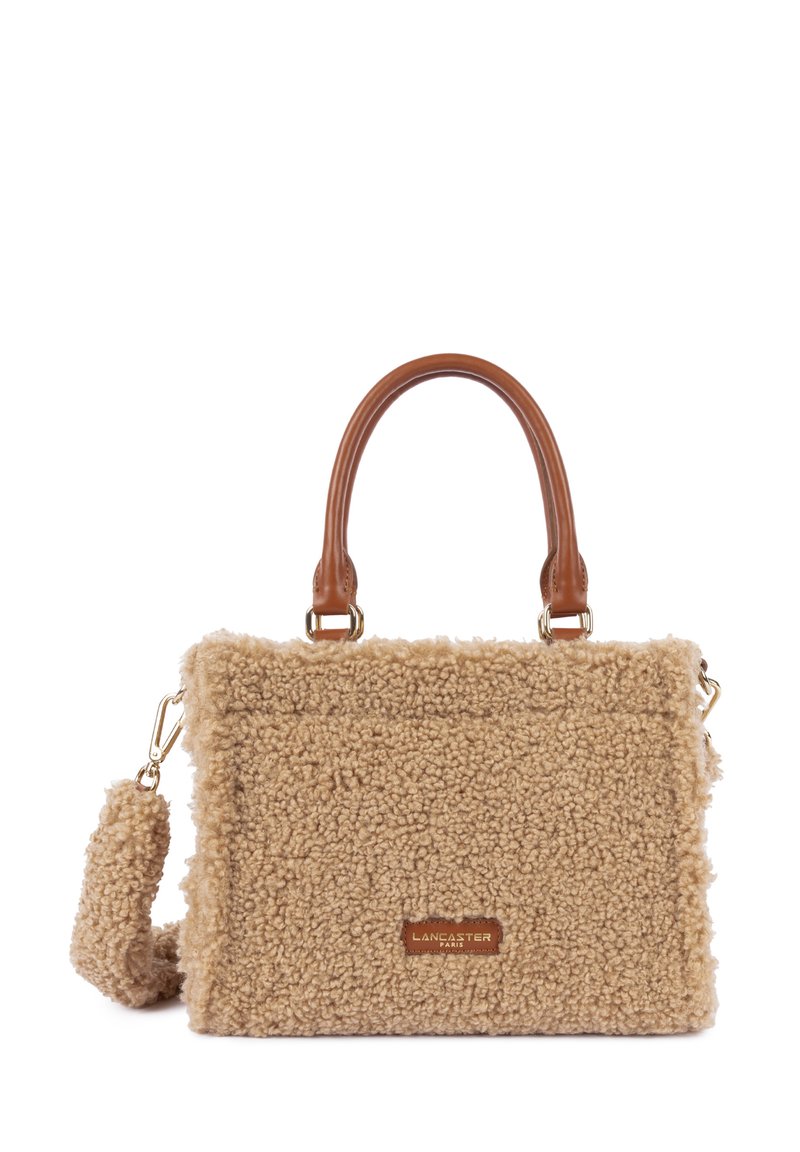 Borsa in pelliccia sintetica beige con manici in pelle marrone, accessori in oro e una tracolla staccabile. Presenta una superficie testurizzata e un'etichetta con il marchio.