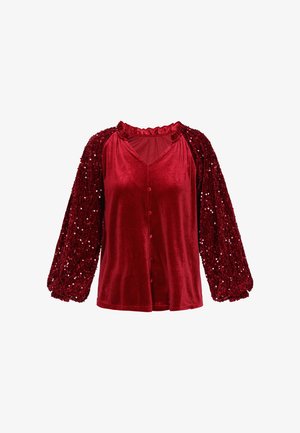 Red velvet top with a V-neckline, button front, and puffy sequined sleeves. Features ruffled collar and textured fabric on sleeves.