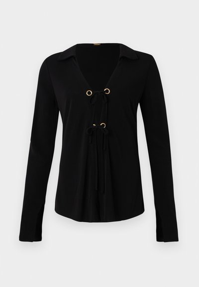 Black long-sleeve shirt with a V-neck, gold grommets, and adjustable ties at the front. Made of soft fabric with a smooth texture.