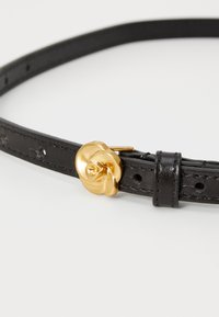 Zwarte leren riem met een gedraaide gouden metalen gesp, met een gladde textuur en verstelbare maatgaten.