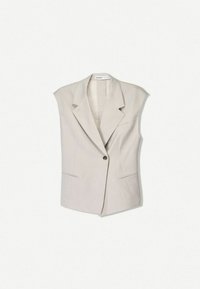Ärmlös beige blazerjacka, tillverkad av ett mjukt tyg, med en enda knäppning, slagkrage och två framfickor.