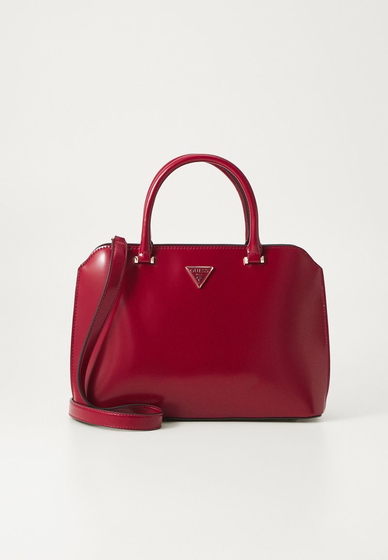 Borsa a tracolla in pelle verniciata rossa con doppio manico superiore, tracolla removibile e accento del logo in metallo sulla parte anteriore. Forma strutturata con superficie liscia.