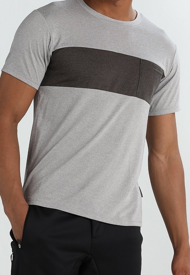 Camiseta gris de manga corta con una franja horizontal de un gris más oscuro y un bolsillo en el pecho. Fabricada en una tela suave, presenta un corte relajado.