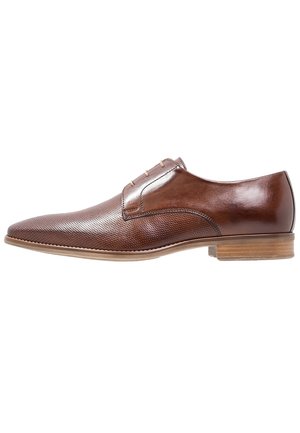 Chaussure habillée pour homme en cuir marron avec un bout perforé, un laçage, et une semelle en bois, présentée en profil latéral sur fond blanc.