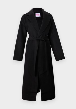 Manteau en laine noire avec col châle, manches longues, ceinture à nouer à la taille et poches latérales. Présente un design minimaliste et une texture lisse.