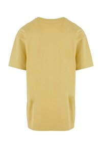 Simpel beige t-shirt med korte ærmer, set bagfra med rund halsudskæring og en lige kant.