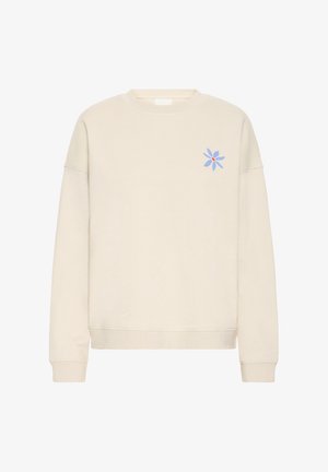 Helebeež tooniga kreemisärgis, valmistatud pehmest kangast. Vasakul rinnapiirkonnal sinine lillemuster ning soonilised mansetid ja alanääris.