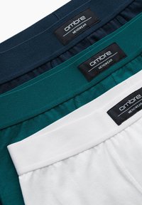 Trois paires de boxers pour hommes en bleu marine, teal et blanc. Chacune a une taille noire avec l'étiquette "ombre". La texture est lisse.