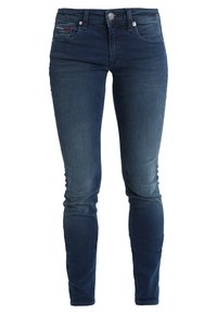 Vaqueros de mezclilla azul oscuro con corte slim, que cuentan con un cierre de botón, cinco bolsillos y un ligero desgastado para añadir textura.