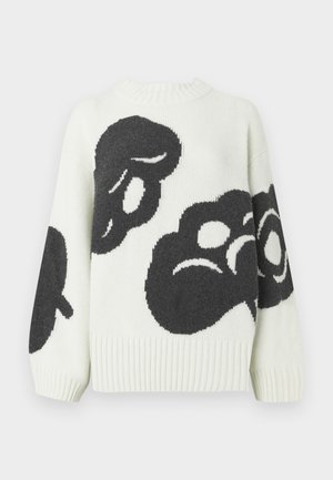 Gebreide trui in crème met grote zwarte abstracte patronen. Voorzien van een geribbelde ronde hals en brede mouwen voor een relaxte pasvorm.