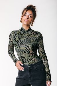 Body à manches longues en maille verte transparent avec un motif imprimé tigre et léopard. Col montant et coupe ajustée. Associé à un jean noir.