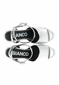 Zilveren sandalen met banden, een gestructureerde afwerking, open teen en gespsluiting. De zwarte binnenzool heeft de merknaam "BIANCO."