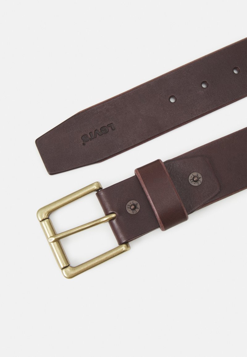 Cintura in pelle marrone con una fibbia in ottone, dotata di un passante cucito, cinque fori di regolazione e un logo stampato sulla cinghia.