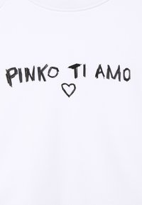 Svarta bokstäver och ett hjärtformat mönster av små svarta pinnar stavar "PINKO TI AMO" på en vit tygbakgrund.